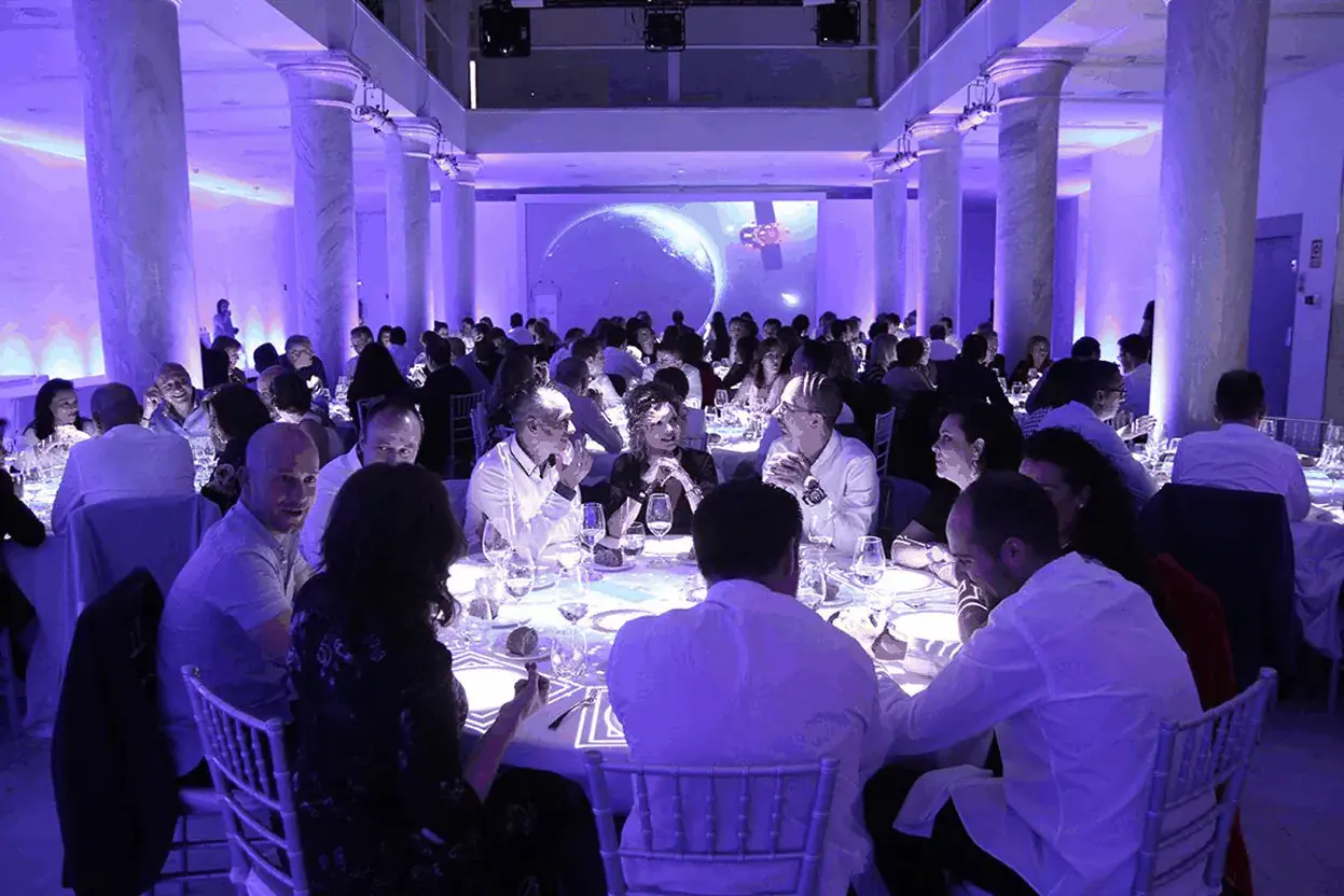 Invitados en una cena de gala de empresa con iluminación de color