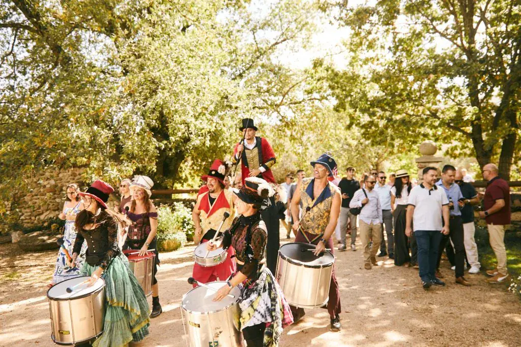 Los empleados llegando a la finca entre la batucada y los personajes de bienvenida