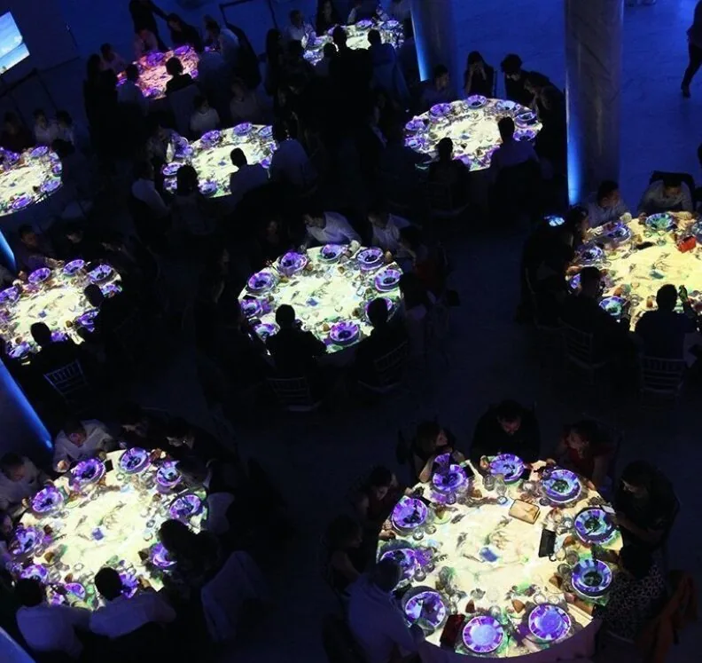Vista cenital de las mesas con el video mapping en marcha durante la cena