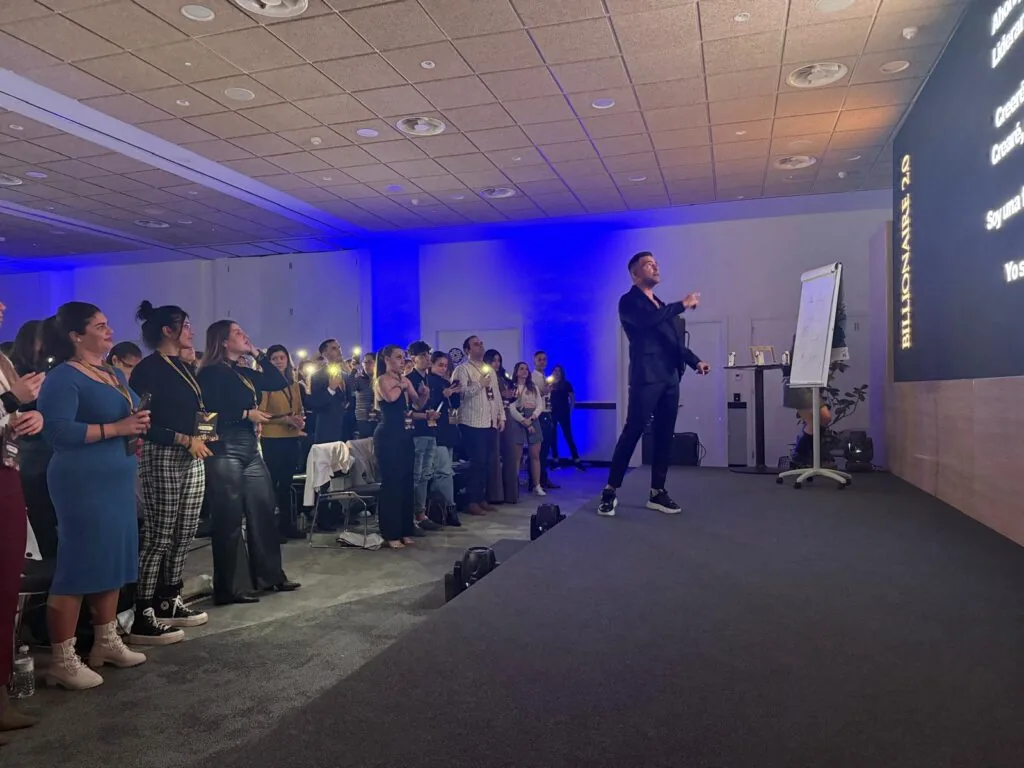 Ponente en el escenario de Billionaire 2.0 con el público en pie