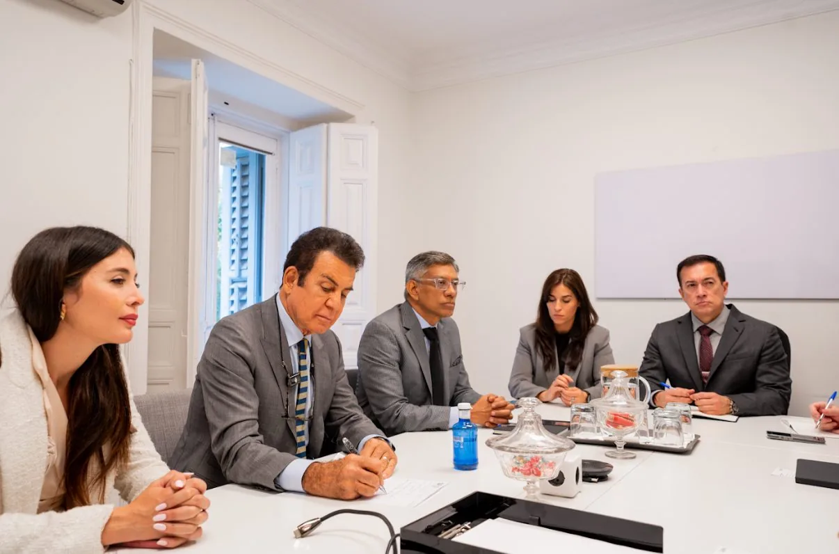 Reunión de trabajo de la delegación en torno a una mesa de juntas con presentación en pantalla