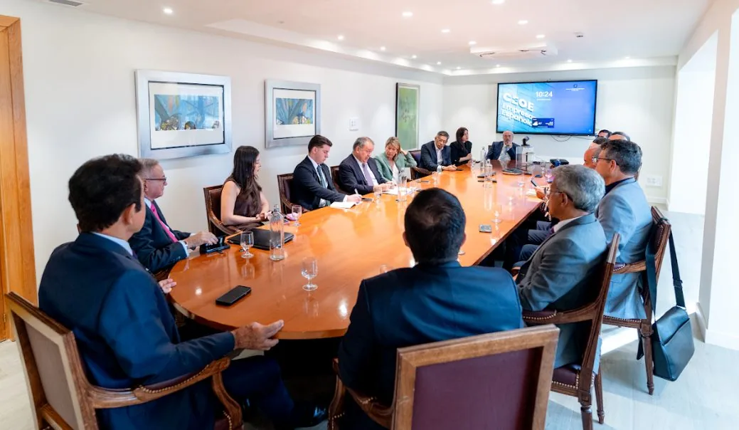 Acto institucional central de la gira con los asistentes sentados y un orador ante la pantalla