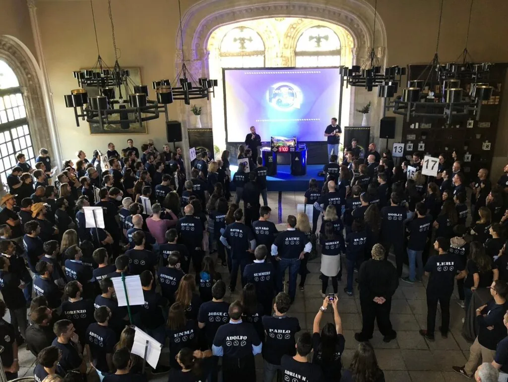 Grupo numeroso con camisetas iguales en una actividad en una sala histórica