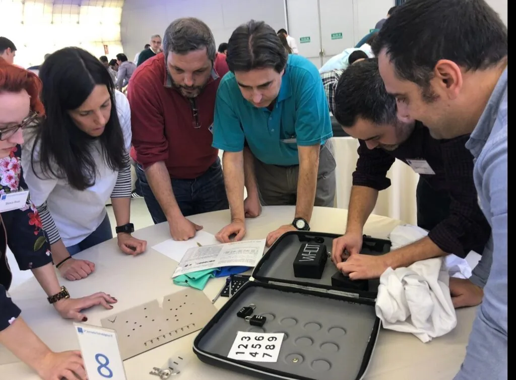 Participantes resolviendo un maletín con candados en una actividad de escape