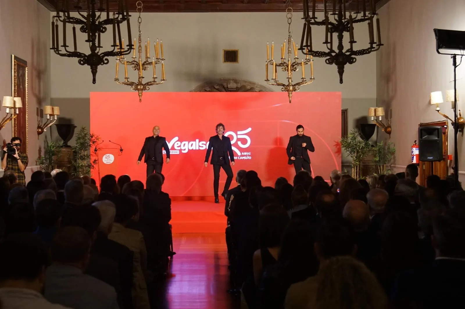 Escenario rojo en un salón con lámparas de araña durante un aniversario de empresa