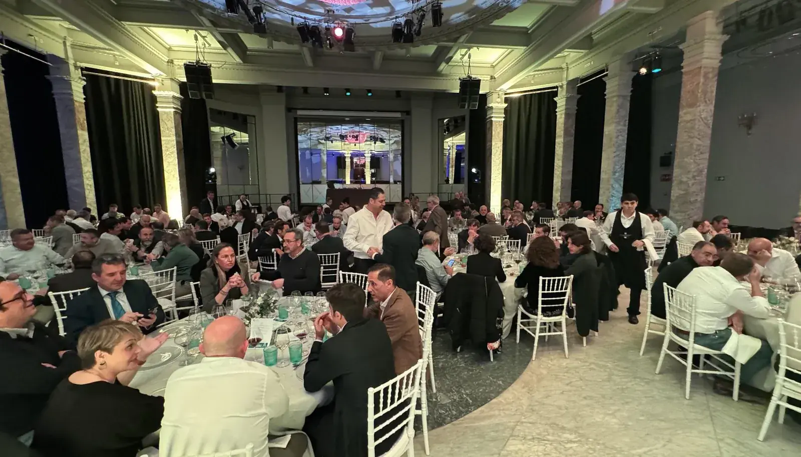 Cena de Navidad de empresa en un salón con mesas redondas