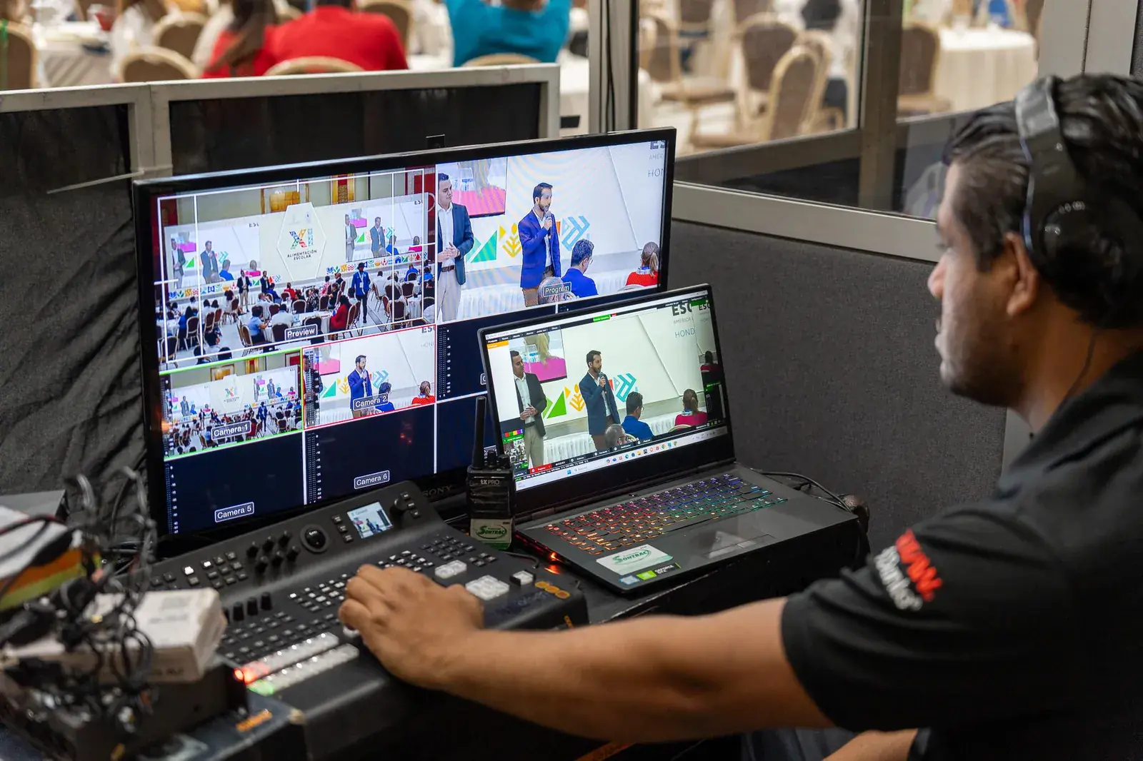 Técnico operando la mesa de realización con varios monitores